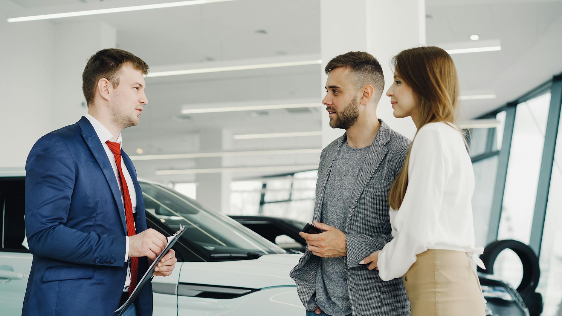 Sprzedawca prezentuje parze luksusowe Renault w nowoczesnym salonie