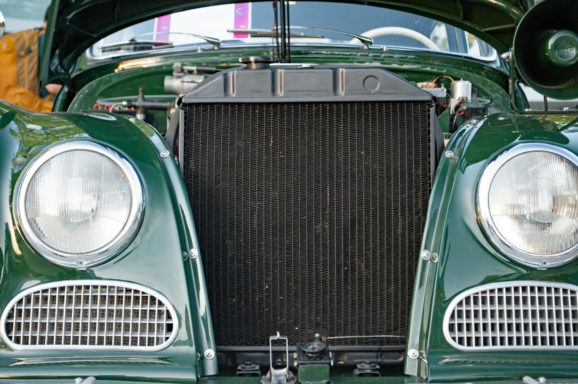 Zbliżenie na chłodnicę i reflektory zielonego klasycznego auta