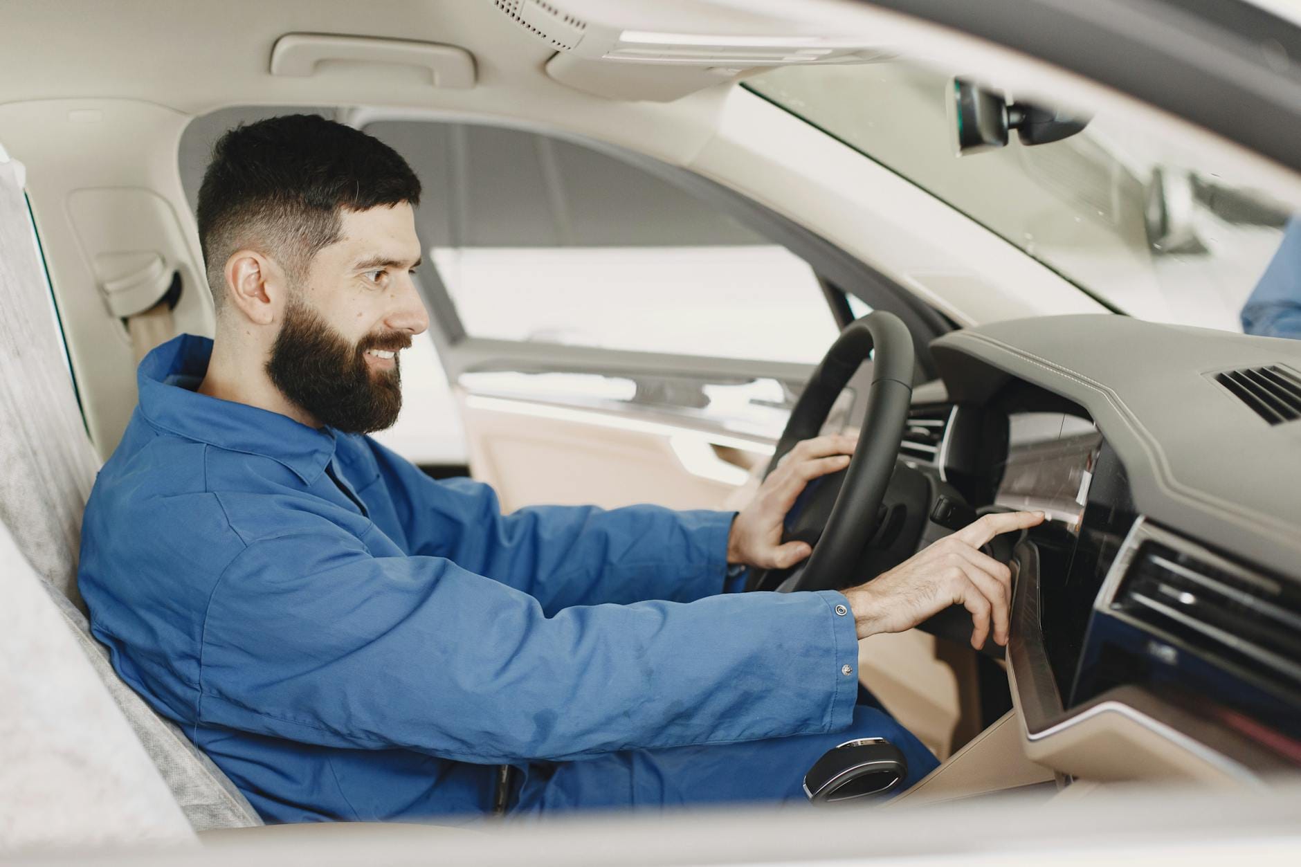Odpowietrzanie układu wspomagania kierownicy w Renault po naprawie Mechanik w niebieskim kombinezonie sprawdza układ kierowniczy w Renault