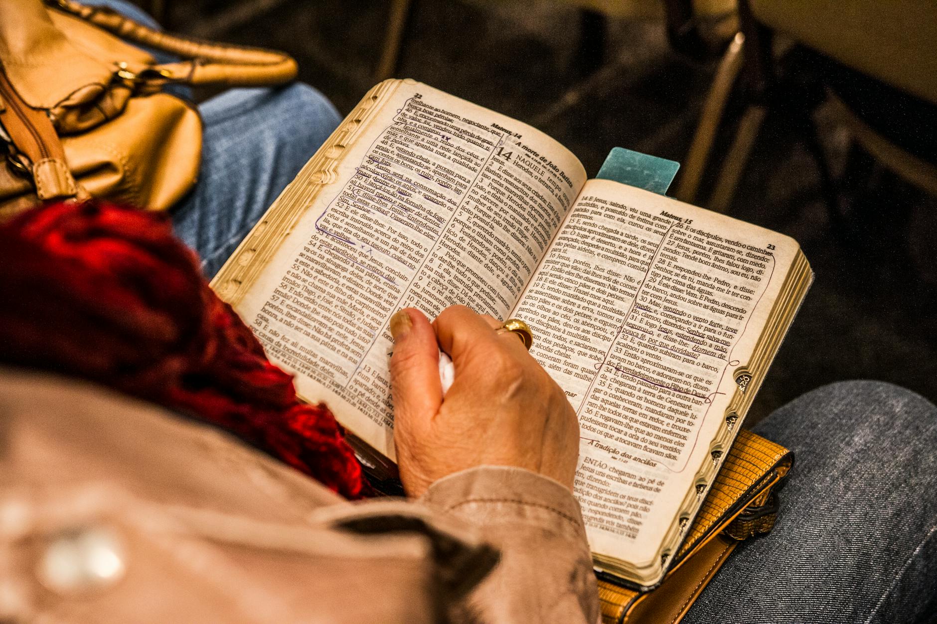 Osoba pogrążona w lekturze Biblii w ciszy domowego wnętrza