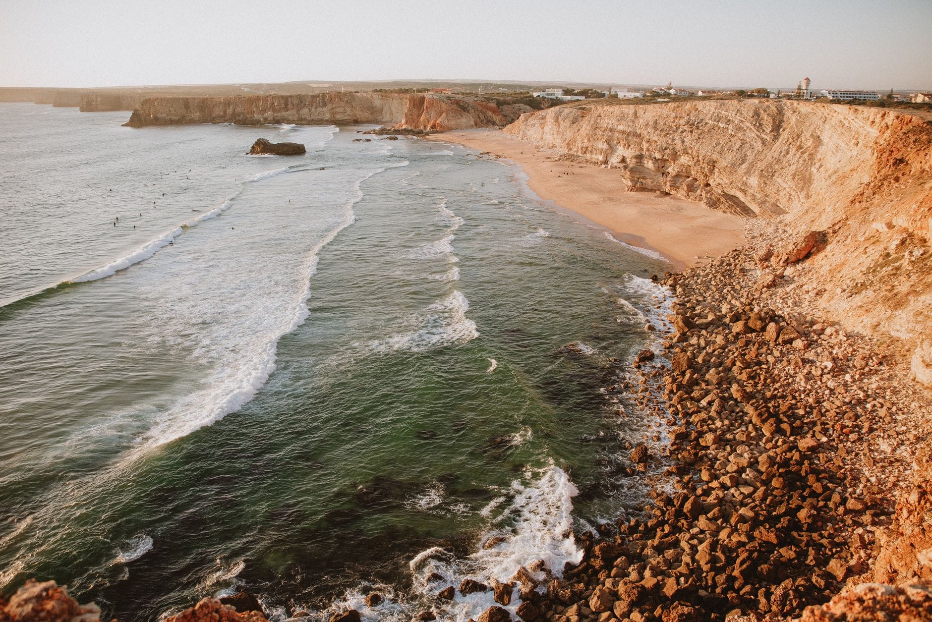 Klifowe wybrzeże Algarve o zachodzie słońca, fale uderzają o plażę Klifowe wybrzeże Algarve o zachodzie słońca, fale uderzają o plażę