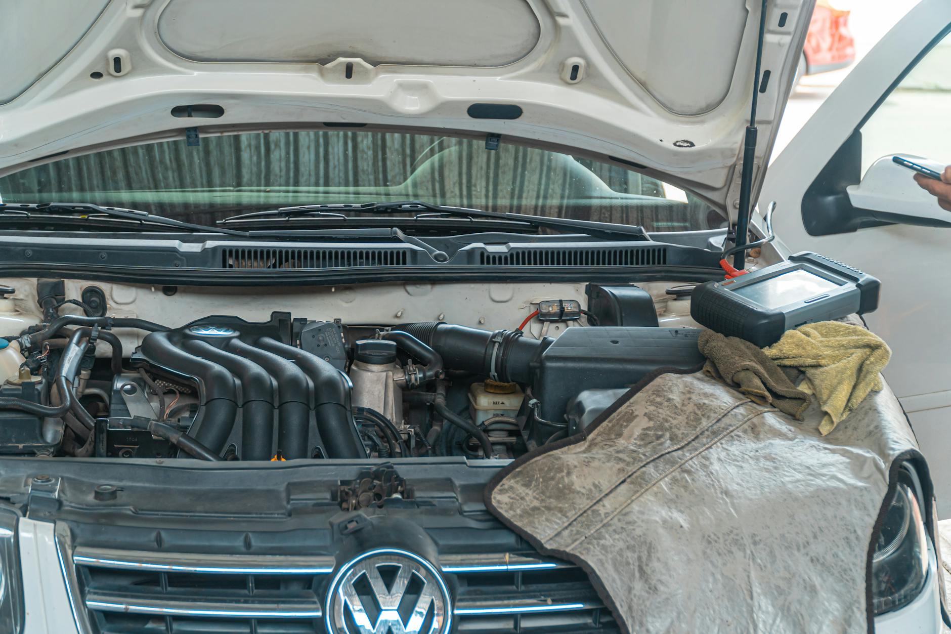 Mechanik diagnozuje silnik Volkswagena za pomocą narzędzi w warsztacie