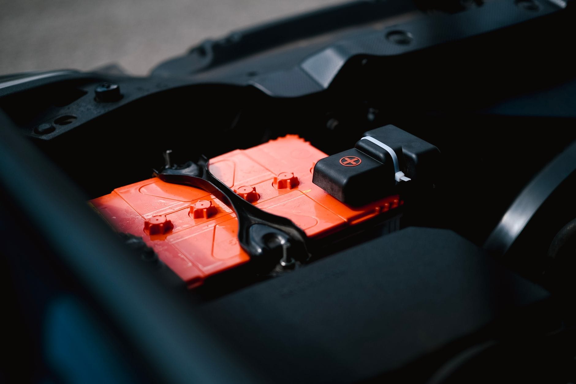 Renault Twingo i małe Renault – typowe problemy z elektryką w mieście, od alternatora po masy nadwozia Pomarańczowy akumulator w komorze silnika małego samochodu Renault