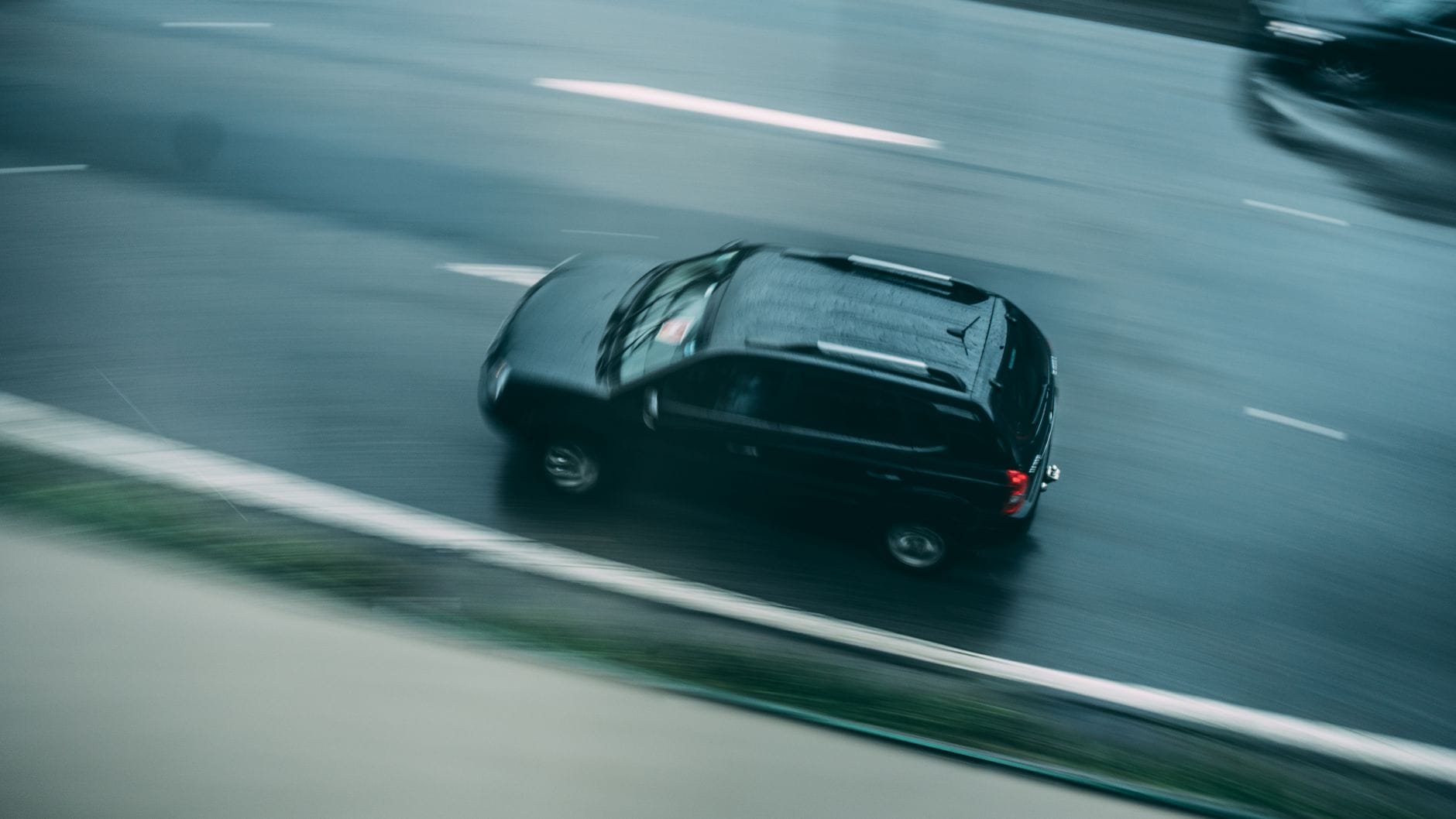 Czarny crossover jedzie szybko po mokrej autostradzie